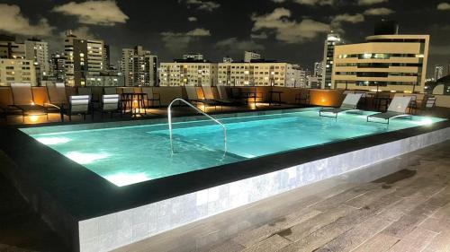 a swimming pool on the rooftop of a building at night at Park Hotel in Recife