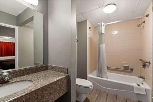 La salle de bains est pourvue d'un lavabo, de toilettes et d'une baignoire. dans l'établissement Rodeway Inn, à Brooklawn