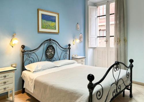 sypialnia z łóżkiem z niebieskimi ścianami i oknem w obiekcie Le Tre Stelle w Cagliari