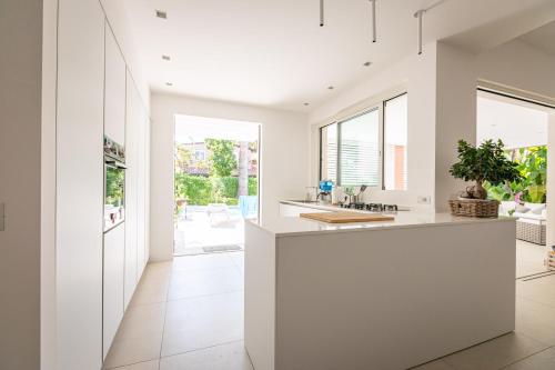 cocina con encimeras blancas y ventanas grandes en Residence Corallo Portorosa Furnari, en Furnari