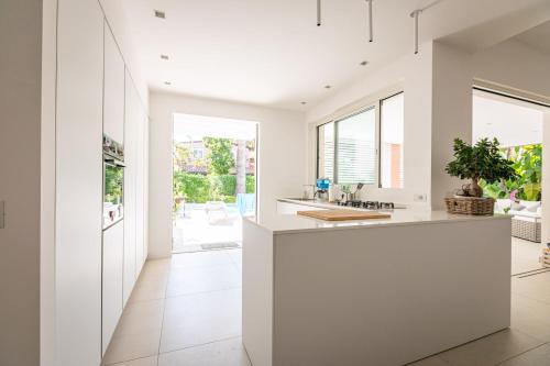 a kitchen with white countertops and large windows at Residence Corallo Portorosa Furnari in Furnari