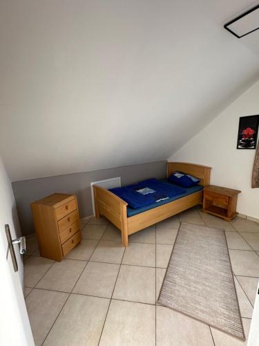 a small bedroom with a blue bed and wooden furniture at Aminas Ferienwohnung Bad Gandersheim 30/2 in Bad Gandersheim