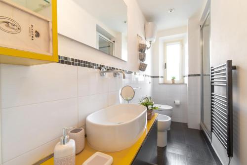 ein weißes Bad mit einem Waschbecken und einem WC in der Unterkunft Piombino Apartments - Casa Milano in Piombino
