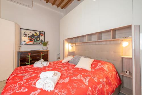 a bedroom with a red bed with towels on it at Piombino Apartments - Casa Mirò in Piombino