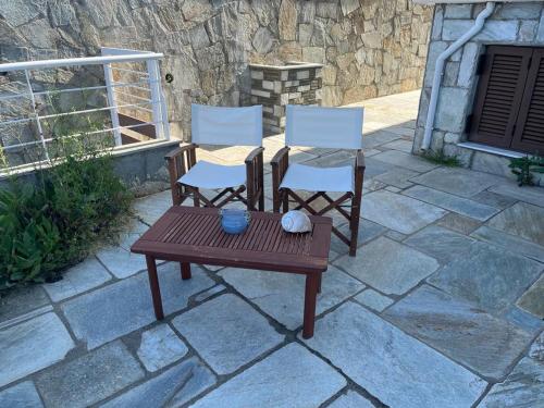 two chairs and a wooden table on a patio at Villa Seaview in Pteleós