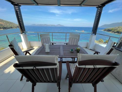 a table and chairs on a balcony with the ocean at Villa Seaview in Pteleós