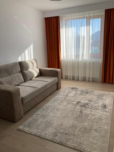 a living room with a couch and a rug at Pensiunea Magic in Băile Govora