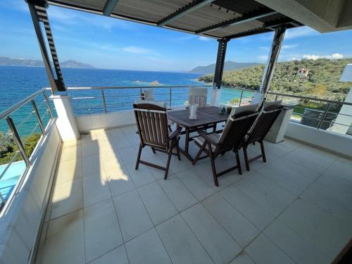 a table and chairs on a balcony with the ocean at Villa Seaview in Pteleós