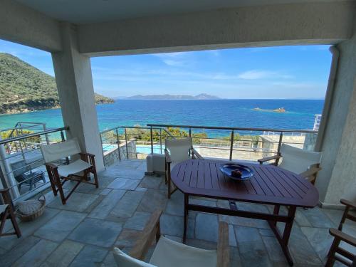 a balcony with a table and chairs and the ocean at Villa Seaview in Pteleós