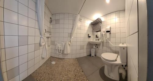 a bathroom with a toilet and a sink at Hotel Le Vanséen in Les Vans