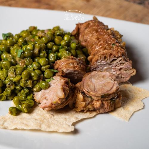 a plate of food with meat and green peas at Hotel Sa Lolla in Barùmini
