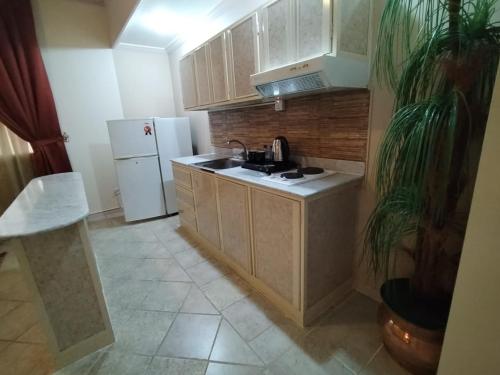 a kitchen with a sink and a white refrigerator at فندق روتانة الحمراء in Jeddah