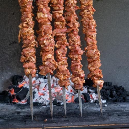 a bunch of food on sticks on a grill at Hotel Sa Lolla in Barùmini