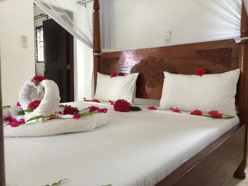 twee bedden met handdoeken en bloemen erop bij Petwac Oasis in Malindi