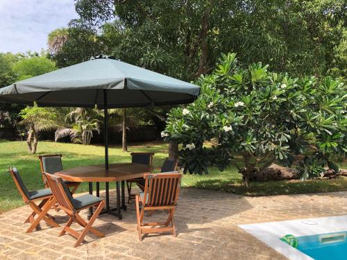 una mesa y sillas con una sombrilla en el patio en Petwac Oasis, en Malindi