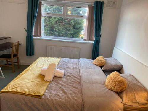 a bedroom with a bed with two towels and a window at The Gold- Home away from home in Manchester