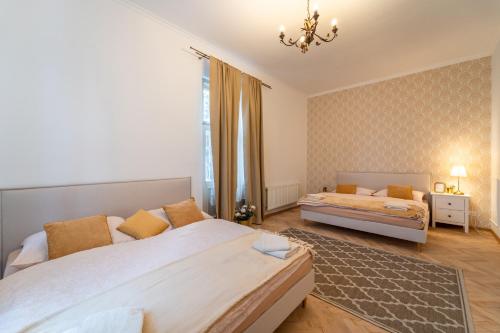 a bedroom with two beds and a chandelier at Resort Červený dvůr in Rapotín