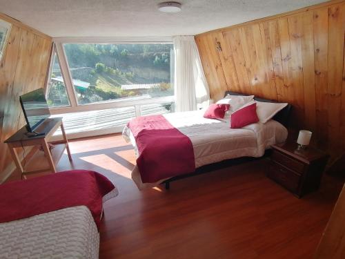 a bedroom with a bed and a large window at CHALET LOS PINOS in Duitama