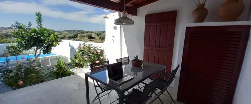 a balcony with a table with a laptop on it at Casa das Rosas in Crato