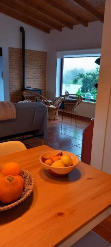 a bowl of oranges on a table in a living room at Casa das Rosas in Crato