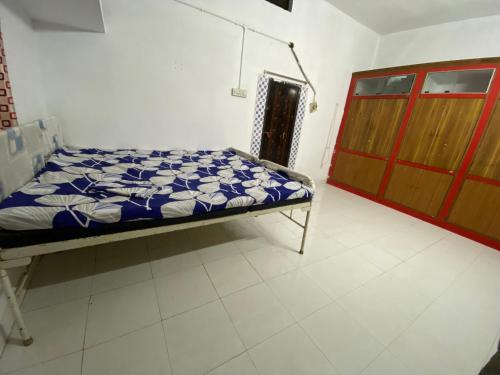 a hospital room with a bed and a wooden door at Morla’s villa in Jagdalpur