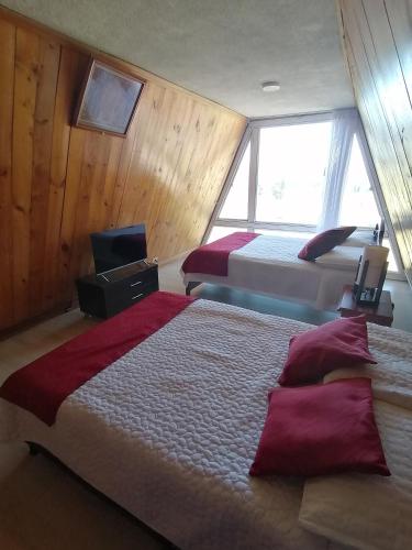 a hotel room with two beds and a window at CHALET LOS PINOS in Duitama