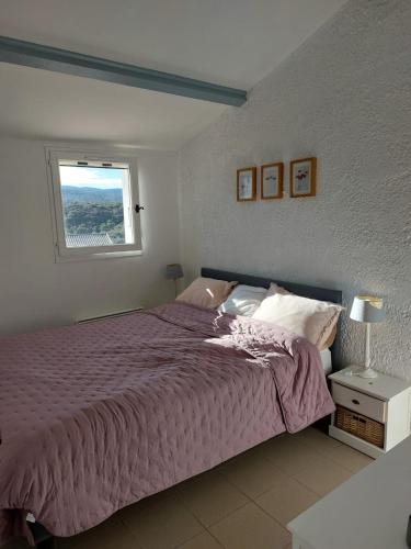 une chambre avec un lit violet et une fenêtre dans l'établissement La Cigale du Pas du Ventoux en Provence, à Mollans-sur-Ouvèze