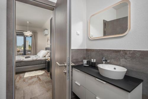 ein Bad mit einem Waschbecken und einem Spiegel in der Unterkunft Villa Dalmatinac in Murvica