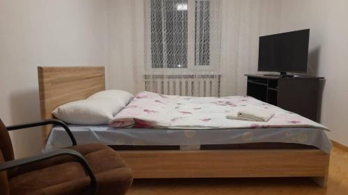 1 dormitorio con 1 cama y TV en Трикімнатна Карпенка біля Порт-Сіті, en Lutsk