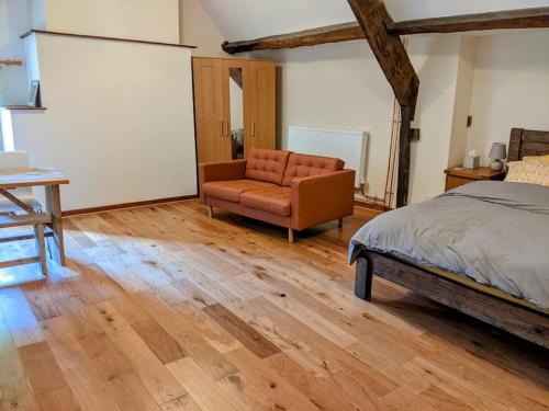 a bedroom with a bed and a chair in it at The Old Granary Farm Cottage in Abergavenny