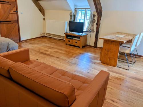 a living room with a couch and a table at The Old Granary Farm Cottage in Abergavenny