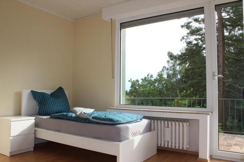 een bed in een kamer met een groot raam bij Mont Apartments in Erkrath