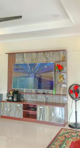 a large entertainment center with a flat screen tv at Villa London Puncak in Sampal 2