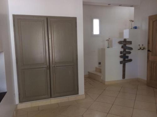 Cette chambre dispose d'un placard en bois et d'une croix sur le mur. dans l'établissement Charmante Bastide 4 chambres avec piscine, à Draguignan