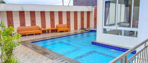 a swimming pool in the middle of a building at Villa London Puncak in Sampal 2