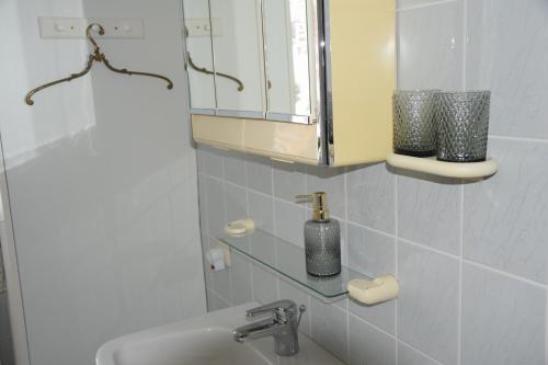 ein Bad mit einem Waschbecken und einem Spiegel in der Unterkunft Garconniere im ehemaligen Hotel Austria in Gmunden