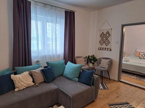 Cozy Town Center Retreat في كومارنو: غرفة معيشة مع أريكة مع وسائد زرقاء