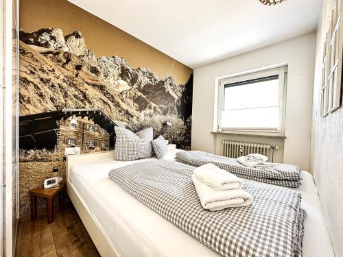 two beds in a bedroom with a mountain mural at Auszeit am Staufen in Oberstaufen