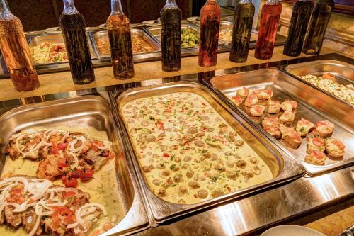 a buffet with many trays of different types of pizzas at Lindos Breeze Beach Hotel in Kiotari