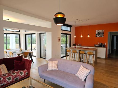 ein Wohnzimmer mit einem Sofa und einer Küche in der Unterkunft Villa vue Imprenable Aber Benoît in Saint-Pabu