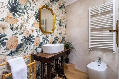 ein Bad mit einem Waschbecken und einem Spiegel in der Unterkunft Adelaide al Borgo. in Castelnuovo di Porto