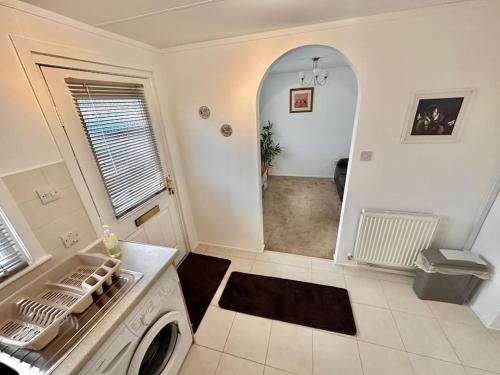 uma cozinha com uma máquina de lavar roupa num quarto em Semi-detached 1-Bedroom Chalet em Uddingston