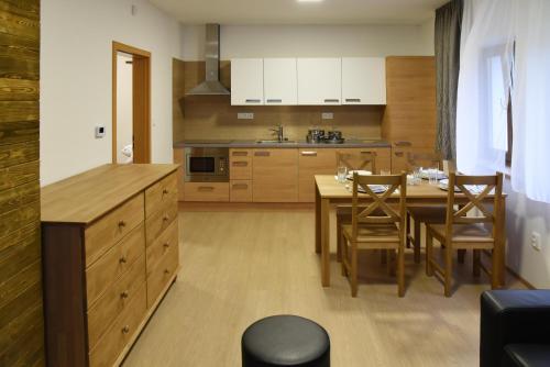 eine Küche und ein Esszimmer mit einem Tisch und Stühlen in der Unterkunft EFI ApartHotel Horní Lipová in Lipová-lázně