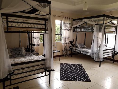 a room with three bunk beds and a rug at The House of Black and White in Arusha
