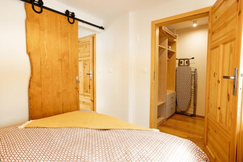 a bedroom with a bed and a wooden door at Na Bogówce in Zakopane
