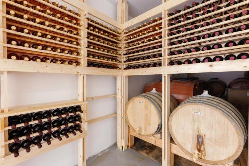 Mikra Bay Vineyard Guesthouses في ناكسوس تشورا: قبو للنبيذ مع رفوف خشبية من زجاجات النبيذ