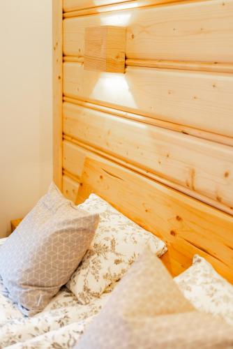a bed with a wooden headboard and pillows on it at Na Bogówce in Zakopane