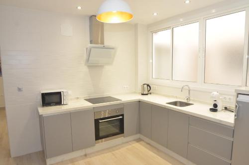 a kitchen with a sink and a microwave at Alojamiento Beethoven Luxury in Málaga