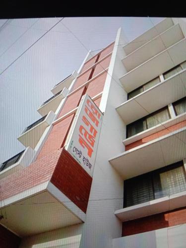 a building with a sign on the side of it at Rose Garden Guest House in Khulna