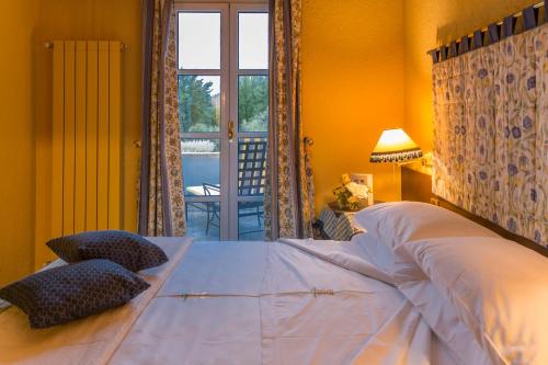 a bedroom with a large bed and a window at La Meridiana ReIais & Chateaux in Garlenda